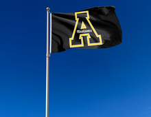 Load image into Gallery viewer, Black 3x5 foot wide Appalachian State University Flag with black A Mountaineers Logo and Two metal grommets attached to flagpole waving in the wind
