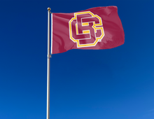 Load image into Gallery viewer, Red 3x5 foot wide Bethune Cookman University Flag with BC Logo and Two metal grommets attached to flagpole waving in the wind
