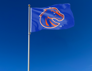 Blue 3x5 foot wide Boise State University Flag with Orange and Blue Bronco and two metal grommets attached to flagpole waving in the wind