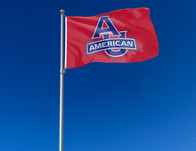 Load image into Gallery viewer, Red 3x5 foot wide American University Flag with Two Metal Grommets attached to a flagpole as it waves in the wind
